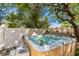 Outdoor hot tub nestled in a private backyard setting, surrounded by mature trees and a fence at 2630 E Dolphin Ave, Mesa, AZ 85204