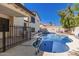 Inviting backyard pool area, surrounded by a patio, fencing, and lush greenery under a clear sky at 2630 E Dolphin Ave, Mesa, AZ 85204
