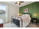 Cozy bedroom with a stylish green accent wall, comfortable bed, and a ceiling fan at 2942 E Appaloosa Rd, Gilbert, AZ 85296