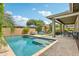 Resort-style pool and outdoor space, featuring lush landscaping, dining area, and covered patio at 2942 E Appaloosa Rd, Gilbert, AZ 85296