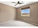 Neutral bedroom with a ceiling fan and a view of desert landscape from the window at 3033 W Redwood Ln, Phoenix, AZ 85045