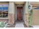 Stylish front entrance featuring a solid wood door, stone accents, and desert landscaping at 3033 W Redwood Ln, Phoenix, AZ 85045