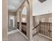 Open hallway with carpet, arches, and wood railing leading to a staircase with natural lighting at 3033 W Redwood Ln, Phoenix, AZ 85045