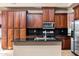 Gourmet kitchen featuring dark wood cabinets, stainless appliances, and island at 3033 W Redwood Ln, Phoenix, AZ 85045