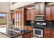 Gourmet kitchen boasts stainless appliances and dark wood cabinets at 3033 W Redwood Ln, Phoenix, AZ 85045