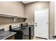 Laundry room with washer, dryer, overhead shelf and access door at 3033 W Redwood Ln, Phoenix, AZ 85045