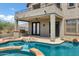 Backyard pool and spa with outdoor kitchen, rock features, and covered patio area at 3033 W Redwood Ln, Phoenix, AZ 85045