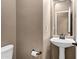 Powder room featuring pedestal sink, framed mirror, and neutral wall texture at 3033 W Redwood Ln, Phoenix, AZ 85045