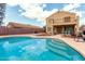 Lush backyard with a sparkling pool, patio, and a two-story home, perfect for entertaining at 309 W Settlers Trl, Casa Grande, AZ 85122