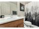 Well-lit bathroom featuring a modern vanity, framed art, and decorative shower curtain at 309 W Settlers Trl, Casa Grande, AZ 85122
