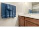 Bathroom vanity area featuring wood cabinets, a white sink, and soft blue towels at 309 W Settlers Trl, Casa Grande, AZ 85122