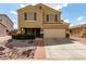 Inviting two-story home featuring a two-car garage, desert landscaping, and a covered front porch at 309 W Settlers Trl, Casa Grande, AZ 85122