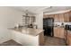 Traditional kitchen with light wood cabinets, neutral countertops, and black appliances at 309 W Settlers Trl, Casa Grande, AZ 85122