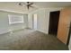 Bedroom offers neutral carpeting, a large window, and a ceiling fan with light at 320 E Mckellips Rd # 152, Mesa, AZ 85201