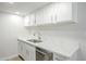 A bright kitchen with white cabinets, stainless steel appliances, and quartz countertops at 3222 W Royal Palm Rd, Phoenix, AZ 85051
