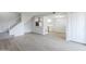 Bright, open-concept living room with modern flooring, staircase and white kitchen in the background at 3222 W Royal Palm Rd, Phoenix, AZ 85051