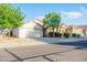 Charming single-story home featuring a two-car garage, desert landscaping, and mature shade trees at 33105 N Double Bar Rd, San Tan Valley, AZ 85144