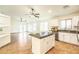 A modern kitchen with white cabinets and a center island opens to a spacious living area at 33105 N Double Bar Rd, San Tan Valley, AZ 85144