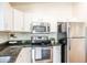 A stainless steel oven and refrigerator are paired with white cabinets and dark countertops at 33105 N Double Bar Rd, San Tan Valley, AZ 85144