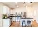 A bright kitchen features stainless steel appliances, white cabinets, and a breakfast bar with seating at 33105 N Double Bar Rd, San Tan Valley, AZ 85144