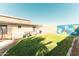 Well-kept backyard with grass, block fence, and wall art, creating an inviting outdoor space at 341 E Constitution Dr, Gilbert, AZ 85296