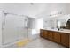 Bathroom featuring a dual sink vanity, walk-in shower with glass doors, and natural light at 341 E Constitution Dr, Gilbert, AZ 85296