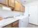 Functional laundry room featuring a sink, cabinets, and modern washer/dryer units at 341 E Constitution Dr, Gilbert, AZ 85296