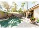 Inviting backyard oasis with a custom pool, mature palm trees, and shaded patio area at 341 E Constitution Dr, Gilbert, AZ 85296