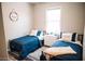 Bright bedroom features two twin beds with matching blue comforters, wood floors, and a dresser at 4313 E Jasper Dr, Gilbert, AZ 85296
