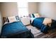 Inviting bedroom features two twin beds with matching blue comforters, wood floors, and a dresser at 4313 E Jasper Dr, Gilbert, AZ 85296