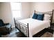 Cozy bedroom showcases an ornate metal bed frame and accent chair in front of a sunny window at 4313 E Jasper Dr, Gilbert, AZ 85296