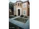 A two-story home with a circular tower and light-colored stucco, small front lawn and sidewalk at 4313 E Jasper Dr, Gilbert, AZ 85296