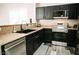 Modern kitchen with black cabinets, stainless steel appliances, and light granite countertops at 4313 E Jasper Dr, Gilbert, AZ 85296