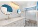 Elegant bathroom with double sinks, white cabinetry, and patterned tile flooring for a luxurious feel at 4518 W Rose Ln, Glendale, AZ 85301