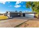 Low angle of exterior showing dark gray siding and white trim, large driveway, and detached two-car garage at 4518 W Rose Ln, Glendale, AZ 85301