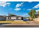 Charming single-story home features a dark gray facade, white trim, desert landscaping, and detached garage at 4518 W Rose Ln, Glendale, AZ 85301