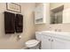 Well-lit bathroom featuring a toilet, sink with white vanity, and a medicine cabinet for ample storage at 4834 E Robin Ln, Phoenix, AZ 85054