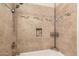 A shower with stone-look tile and a built-in storage niche at 4834 E Robin Ln, Phoenix, AZ 85054