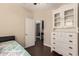 A guest bedroom with wood floors featuring a cabinet, dresser, and open doorway at 4834 E Robin Ln, Phoenix, AZ 85054