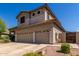Side view of a tan two-story home with a three-car garage and desert landscaping at 4834 E Robin Ln, Phoenix, AZ 85054