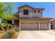 Tan two-story home with a three-car garage, desert landscaping, and a red tile roof at 4834 E Robin Ln, Phoenix, AZ 85054