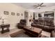 Open-concept living room featuring plush brown leather seating, a coffee table, and neutral decor at 4834 E Robin Ln, Phoenix, AZ 85054