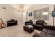 Living room featuring leather couches, tile floors, and a piano at 4834 E Robin Ln, Phoenix, AZ 85054