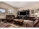 Cozy living room with a large TV, fireplace, brown leather couches, and custom entertainment center at 4834 E Robin Ln, Phoenix, AZ 85054