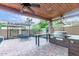 Inviting backyard patio with an outdoor dining area and a built-in grill, creating a perfect space for gatherings at 5443 W Hobby Horse Dr, Phoenix, AZ 85083
