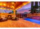 Backyard view of a pool, outdoor fireplace, seating area and covered patio at sunset at 5443 W Hobby Horse Dr, Phoenix, AZ 85083