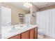 Bathroom featuring a double sink vanity, framed mirror and shower with white curtain at 5443 W Hobby Horse Dr, Phoenix, AZ 85083