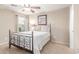 Bedroom features an ornate iron bed frame, ceiling fan, and large window at 5443 W Hobby Horse Dr, Phoenix, AZ 85083