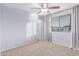 Bedroom featuring neutral walls, carpeting, ceiling fan, and a large window for natural light at 5443 W Hobby Horse Dr, Phoenix, AZ 85083