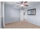 Neutral bedroom with a ceiling fan, carpeted floor, and view to the bathroom at 5443 W Hobby Horse Dr, Phoenix, AZ 85083